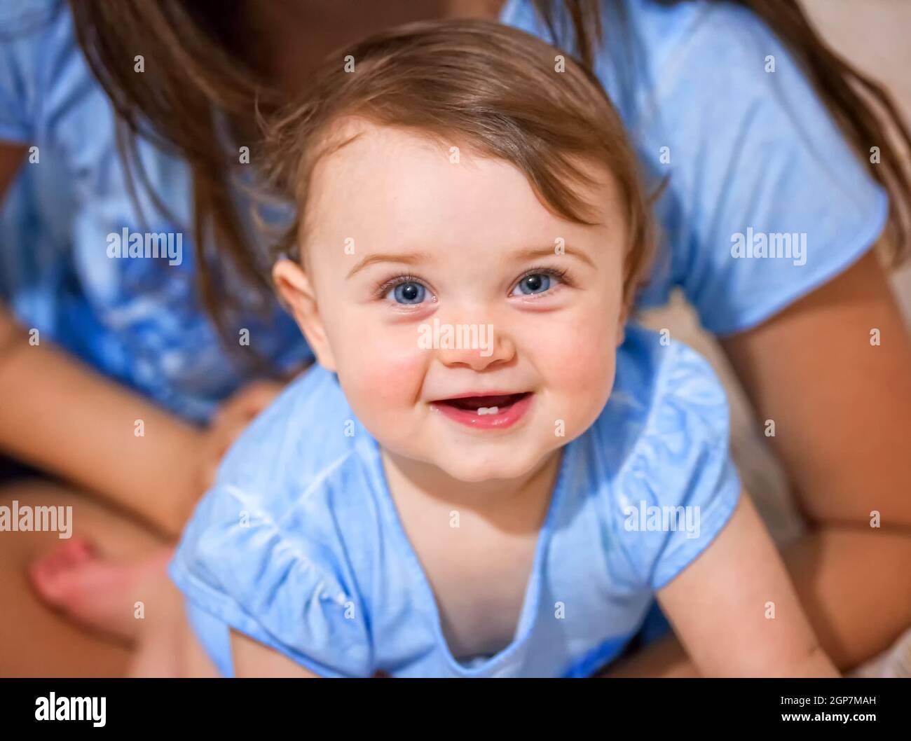 Portrait of a newborn baby girl smiling with two lower teeth. Stock Photo