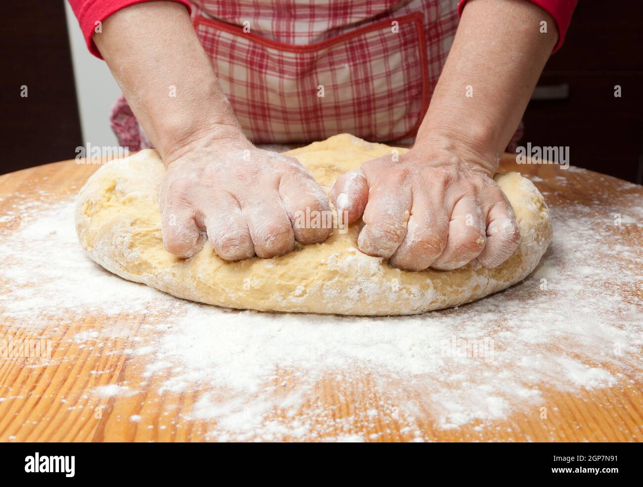 Female hands in flour closeup kneading dough on table Stock Photo - Alamy