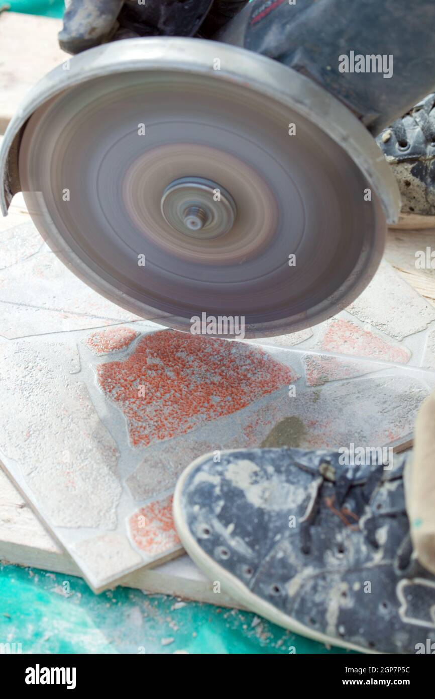 A man cutting a floor tiles with a grinder Stock Photo Alamy