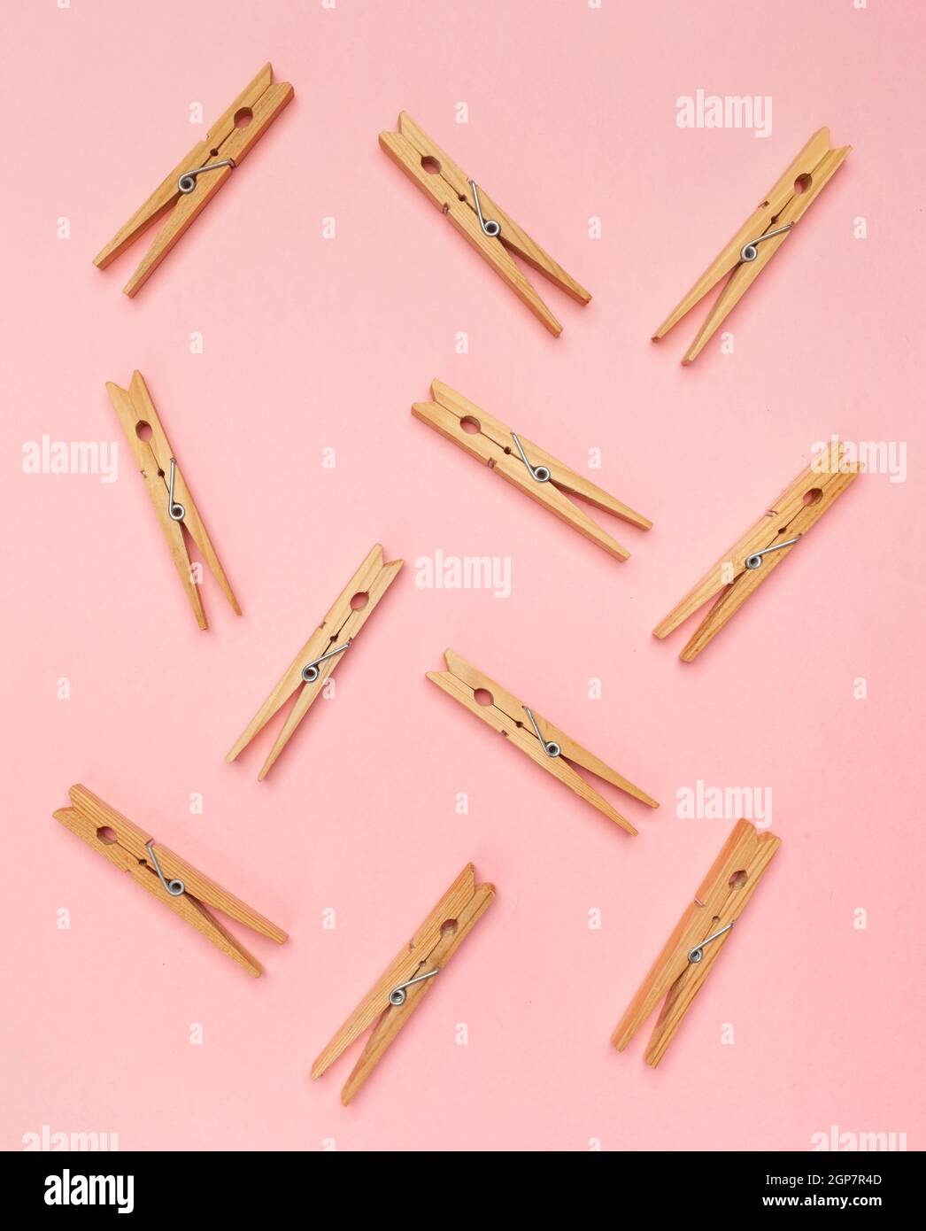 Wooden clothes pins on a pink background. Stock Photo