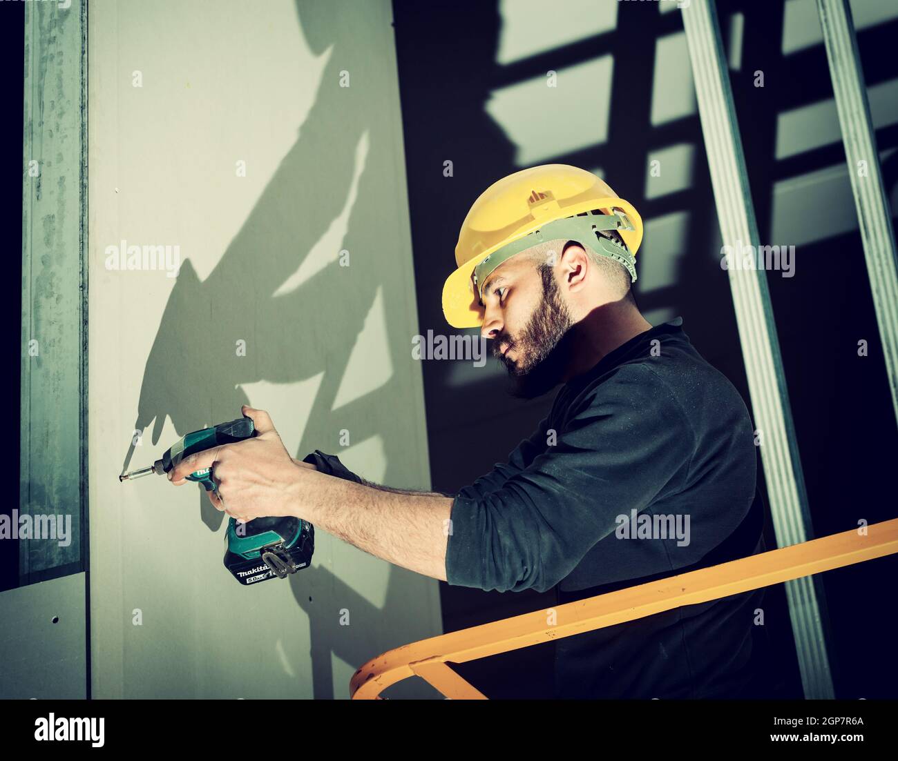 Worker at work in the construction of a plasterboard wall. Stock Photo