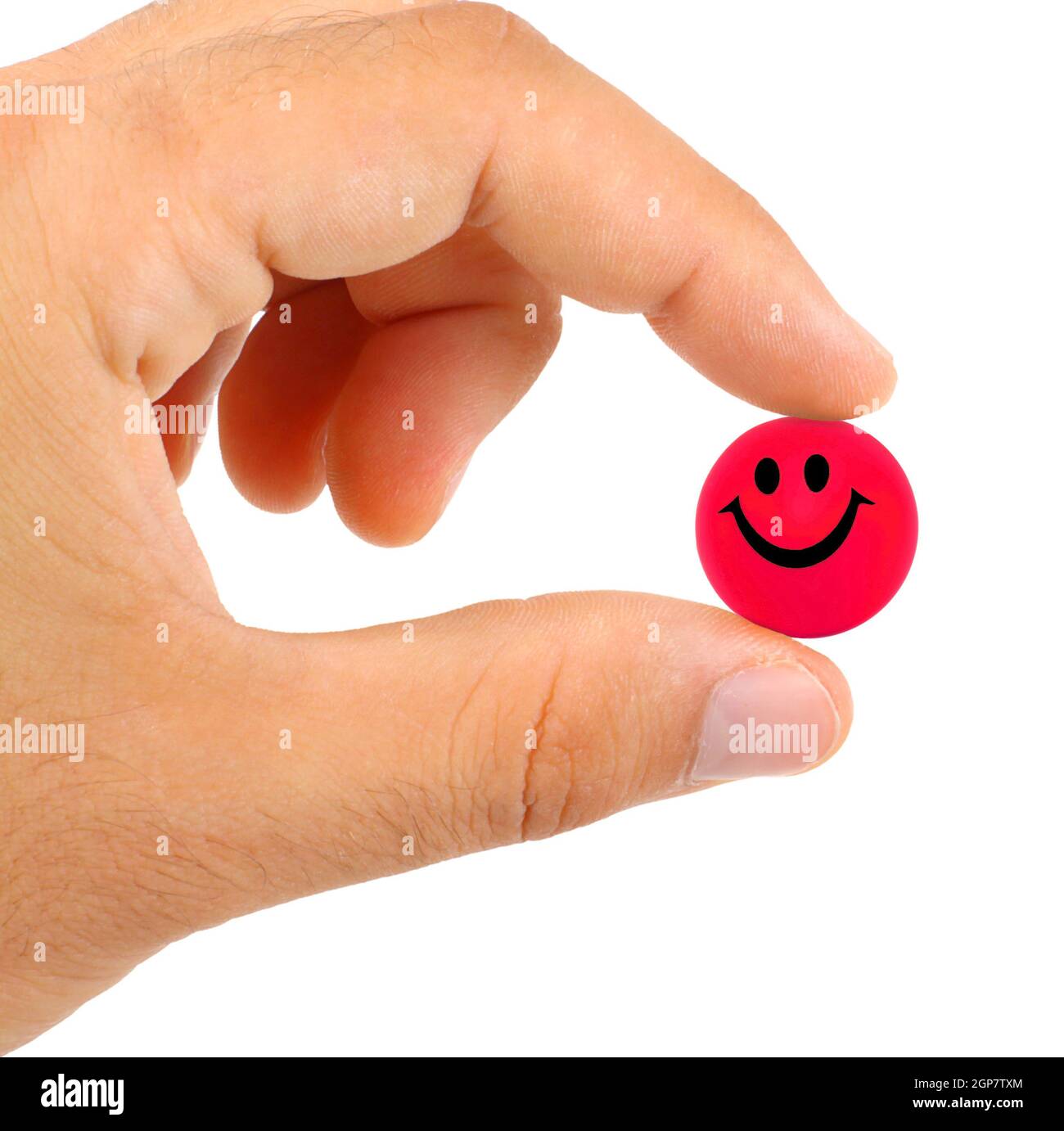 Ball with smile between the fingers on white background Stock Photo