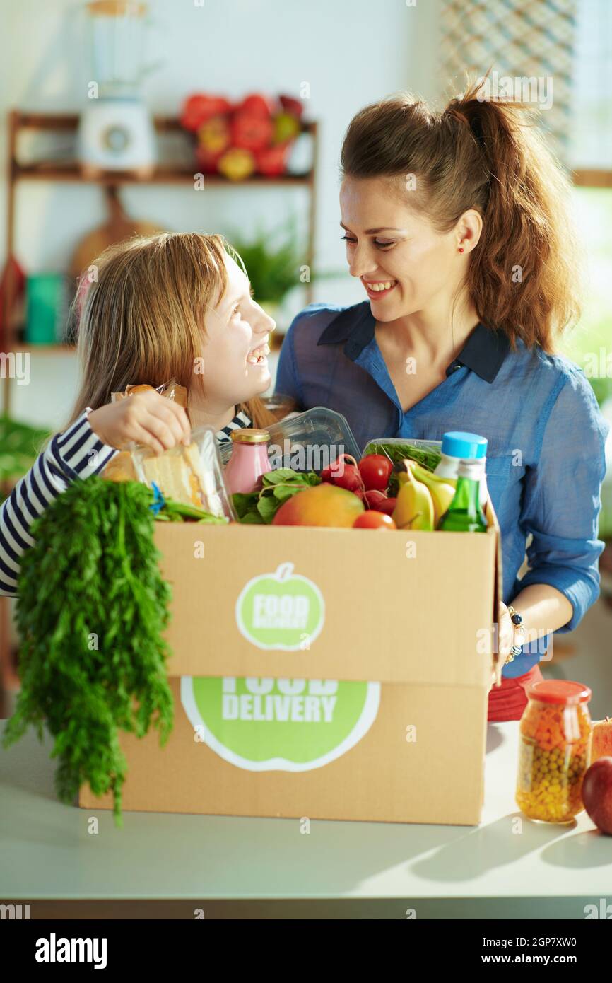 Food delivery. happy modern mother and daughter with food box in the
