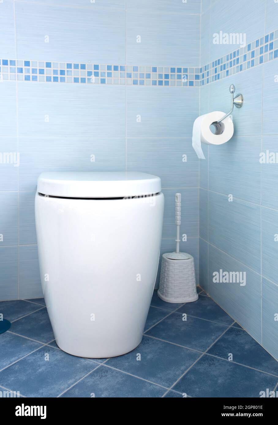 Modern white toilet bowl in blue bathroom Stock Photo Alamy