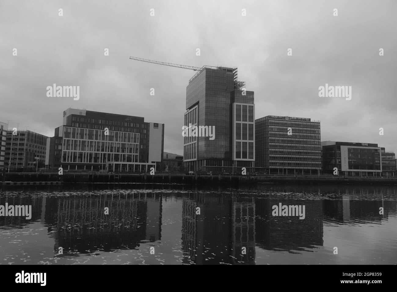 Black and white shot of the reflection of buildings on a canal Stock Photo