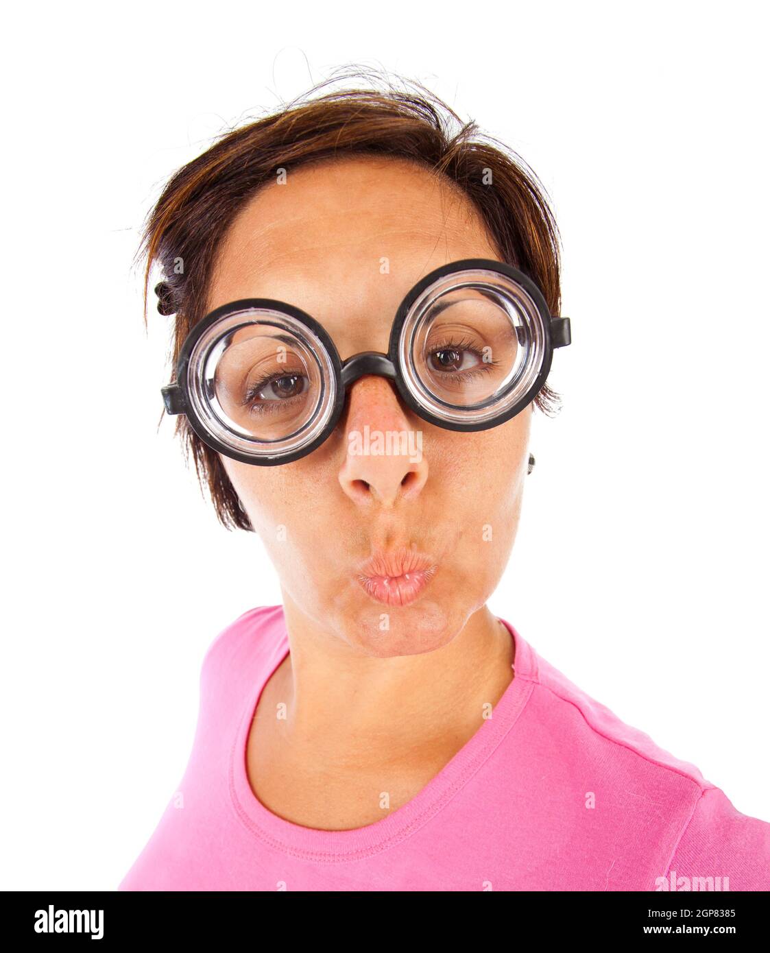 Close up of a young woman with thick glasses and surprised expression