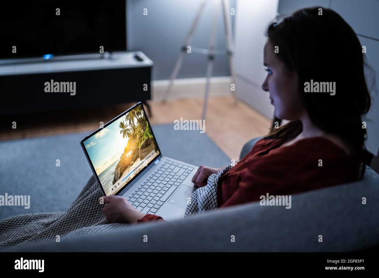 Watch Video Using A Computer Watching TV Video On Laptop Online On Couch Stock Photo - Alamy