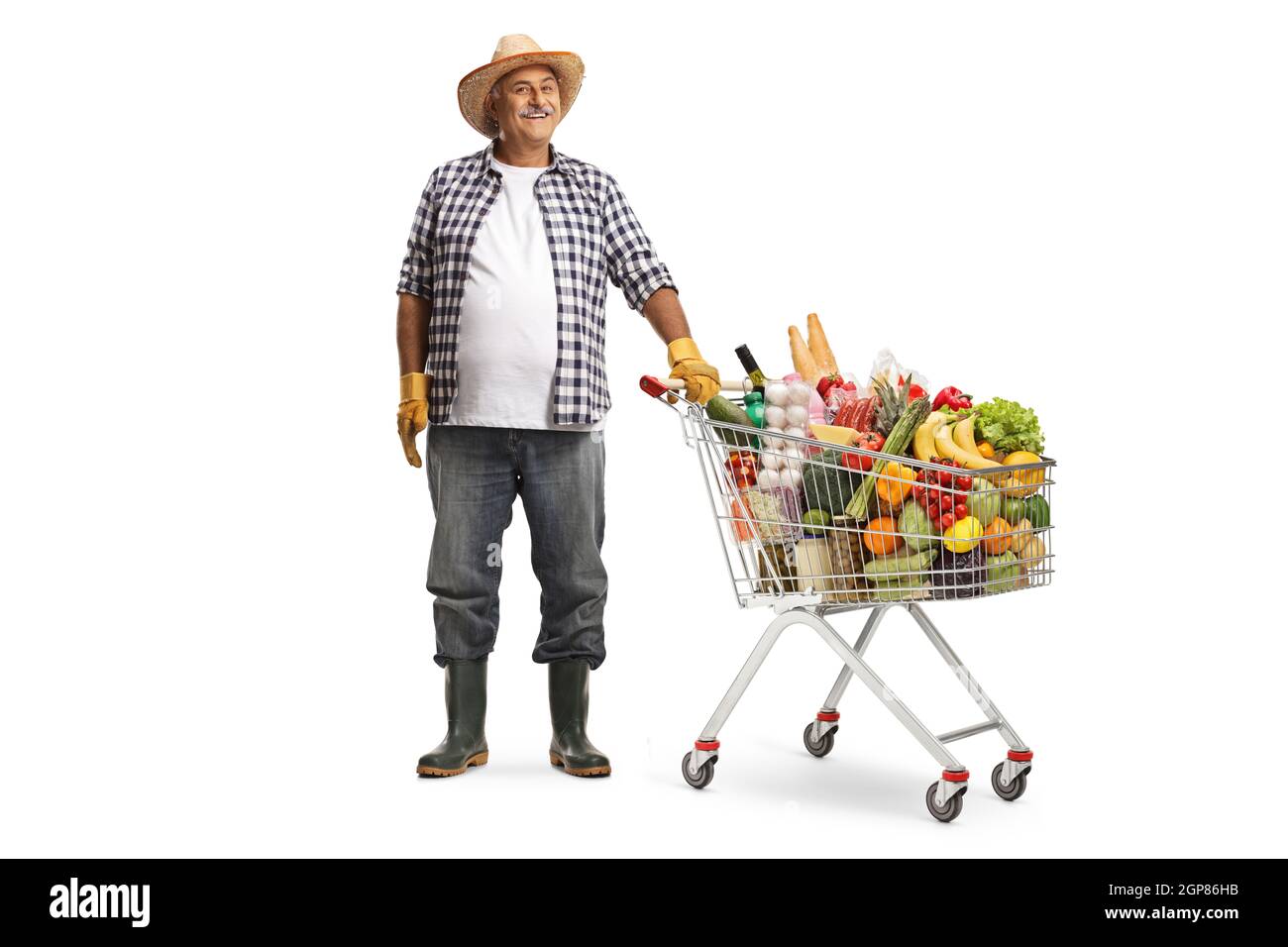 Farmer posing with a shopping cart full of food products isolated on white background Stock Photo