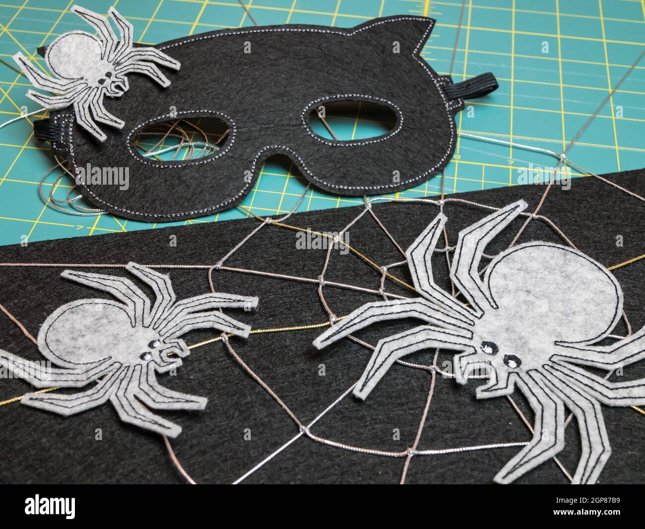 Mask and spiders from felt as the decoration for the Halloween Festival.  Black mask for masquerade DIY Stock Photo - Alamy