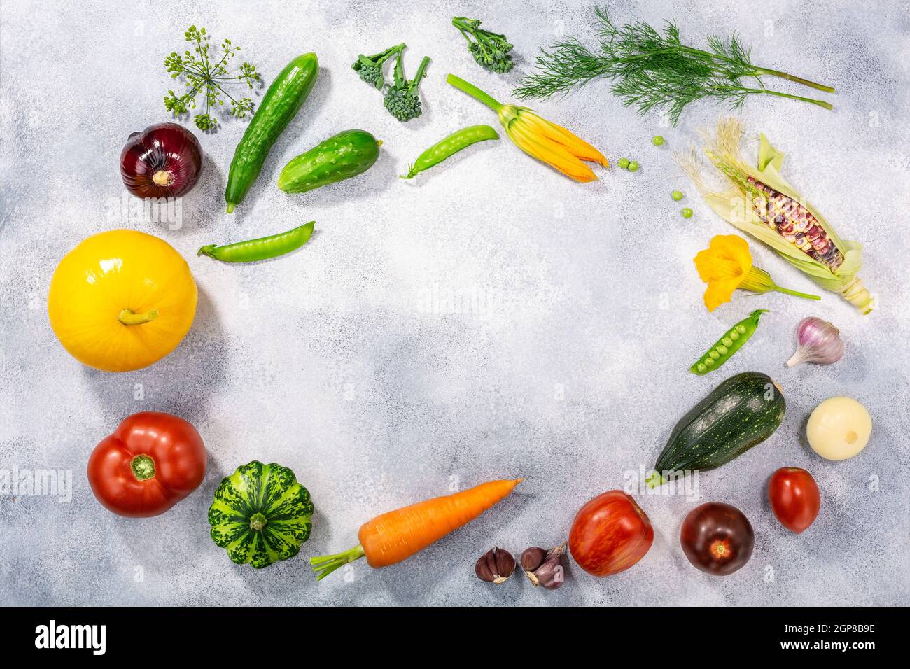 Fresh select seasonal vegetables on light textured backdrop, top view w/ copy space. Locavore movement, eat local, clean eating, farm fresh concept Stock Photo