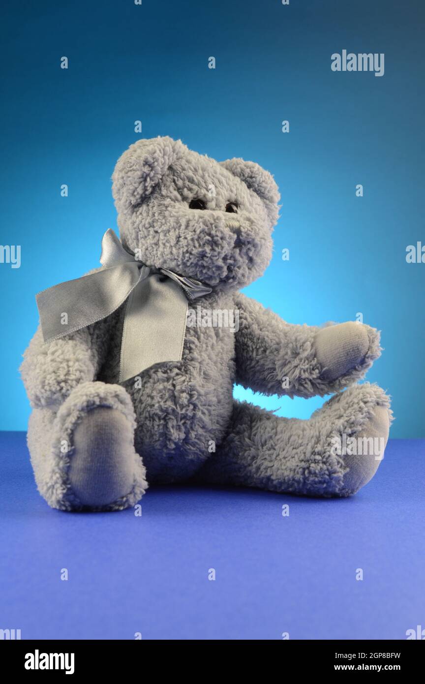 A fluffy blue teddy bear over a complimenting background. Stock Photo