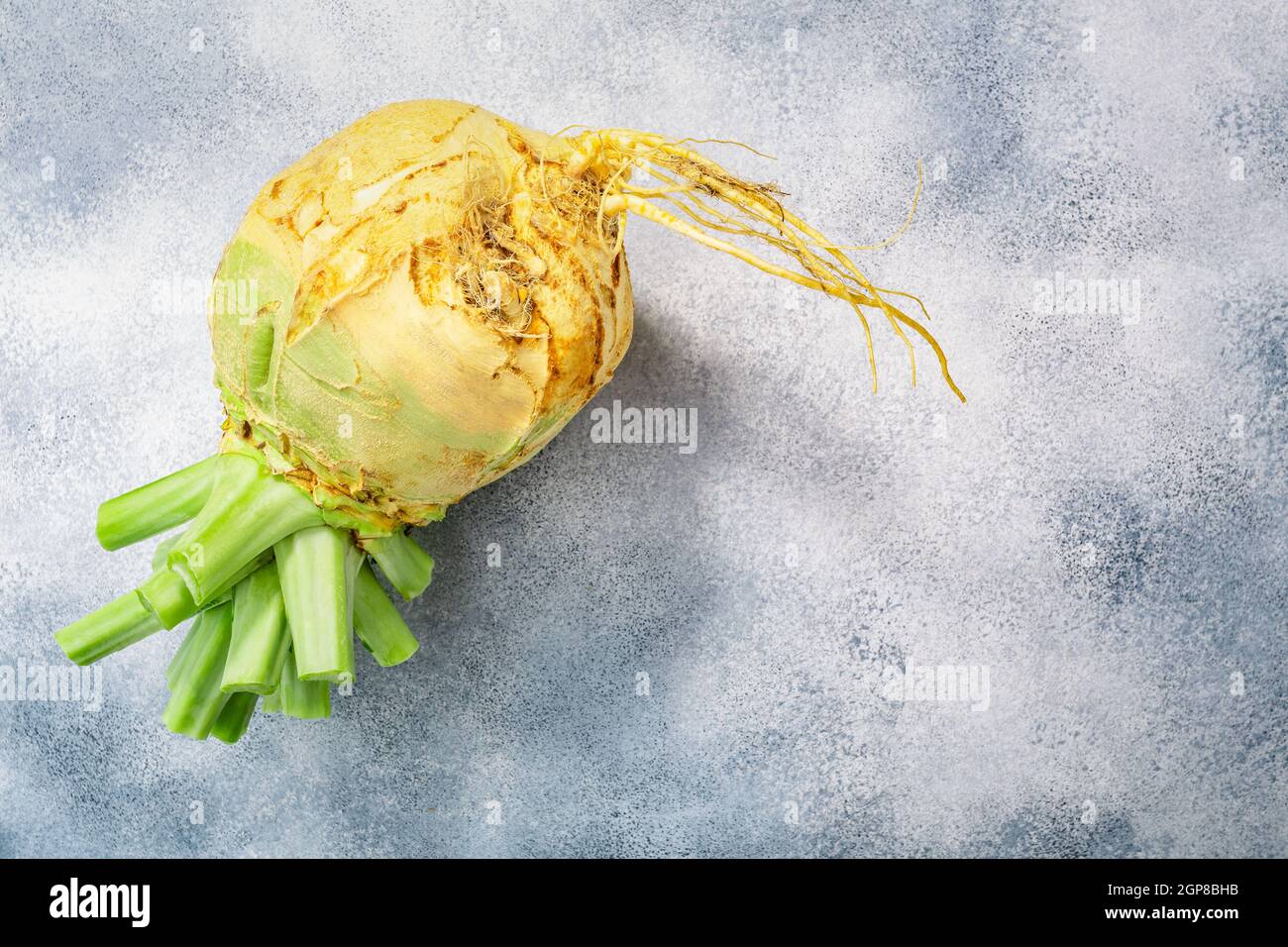 Rutabaga or swede root vegetable atop grey concrete backdrop, top view Stock Photo