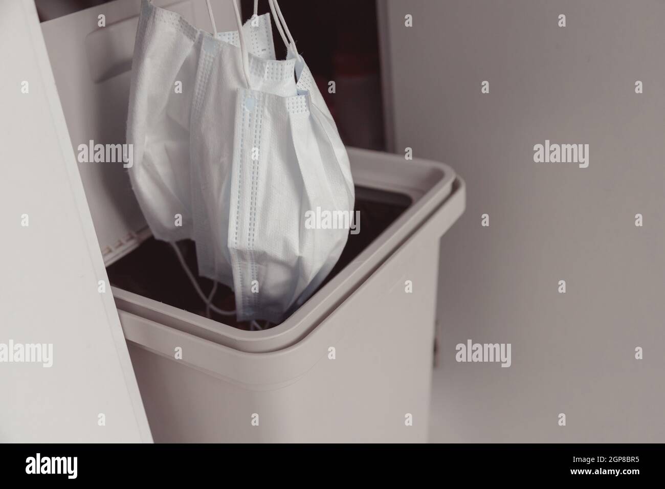 The used face mask is dumped in a trash. Disposal of disposable