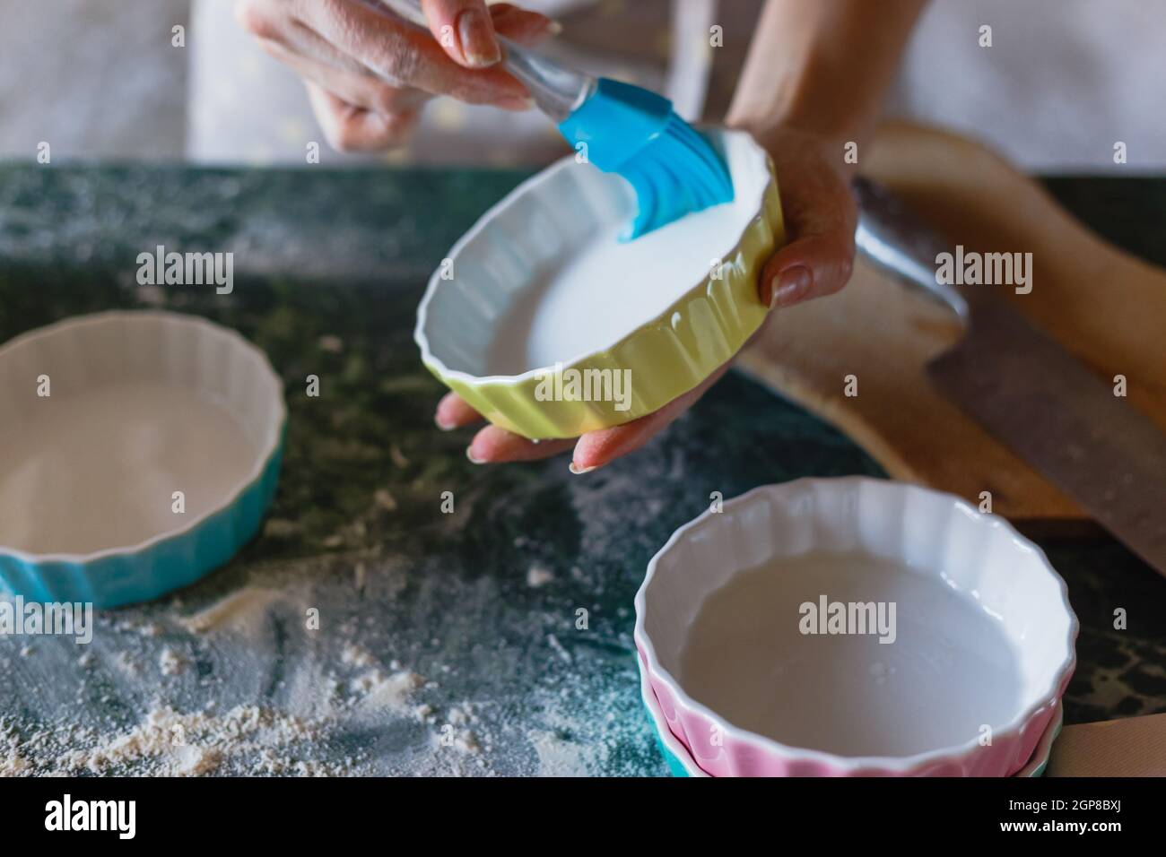Woman greasing baking mould before adding batter. Stock Photo