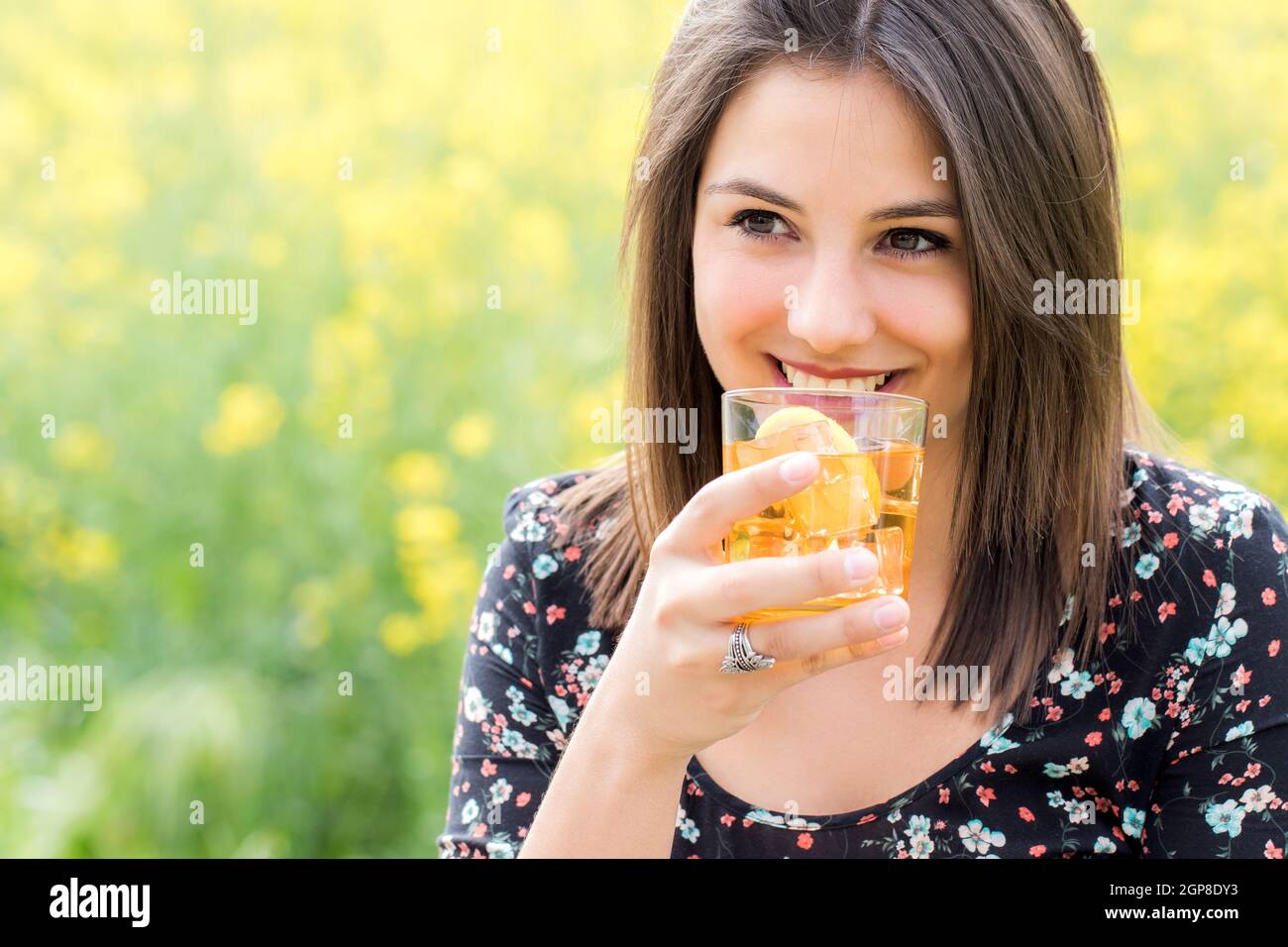 Close up portrait of attractive girl drinking ice tea outdoors against ...