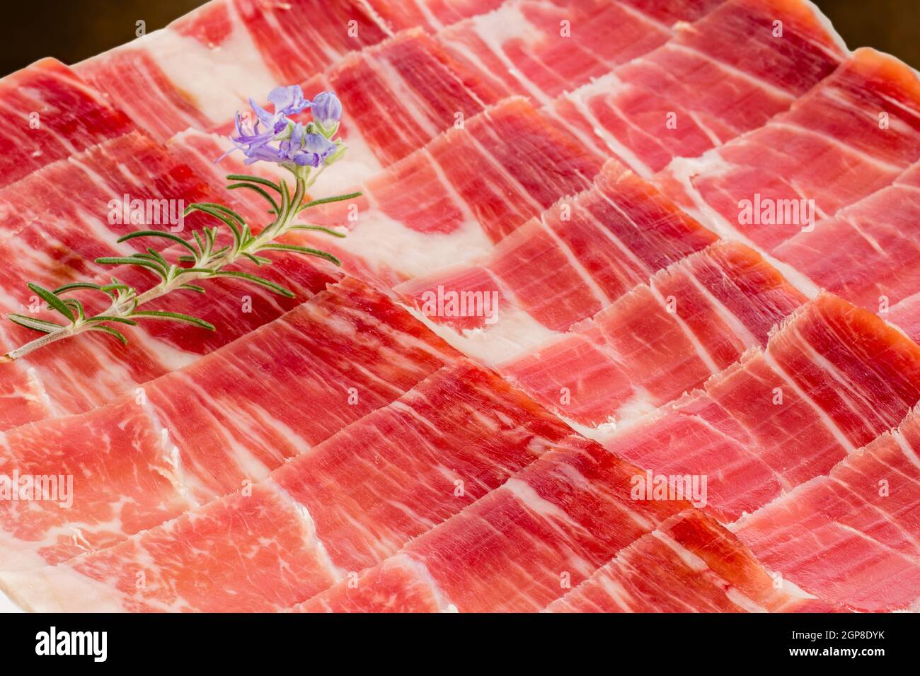 Extreme macro close up pieces of Spanish cured pork ham played out on plate. Stock Photo