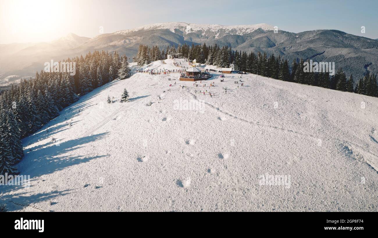 Aerial sun resort at mountain forest. Tourists landmark at nature landscape. Frost and snow at sunny day. Ski slope. People active sport. Vacation at Carpathian mounts, Bukovel, Ukraine, Europe Stock Photo
