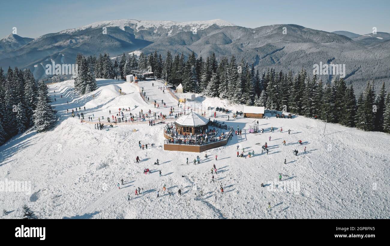 Winter sport resort with ski slope aerial. Snow mountain nature landscape. Tourists extreme sport and recreation. People rest at snowy mount top. Cinematic Carpathians, Bukovel, Ukraine, Europe Stock Photo