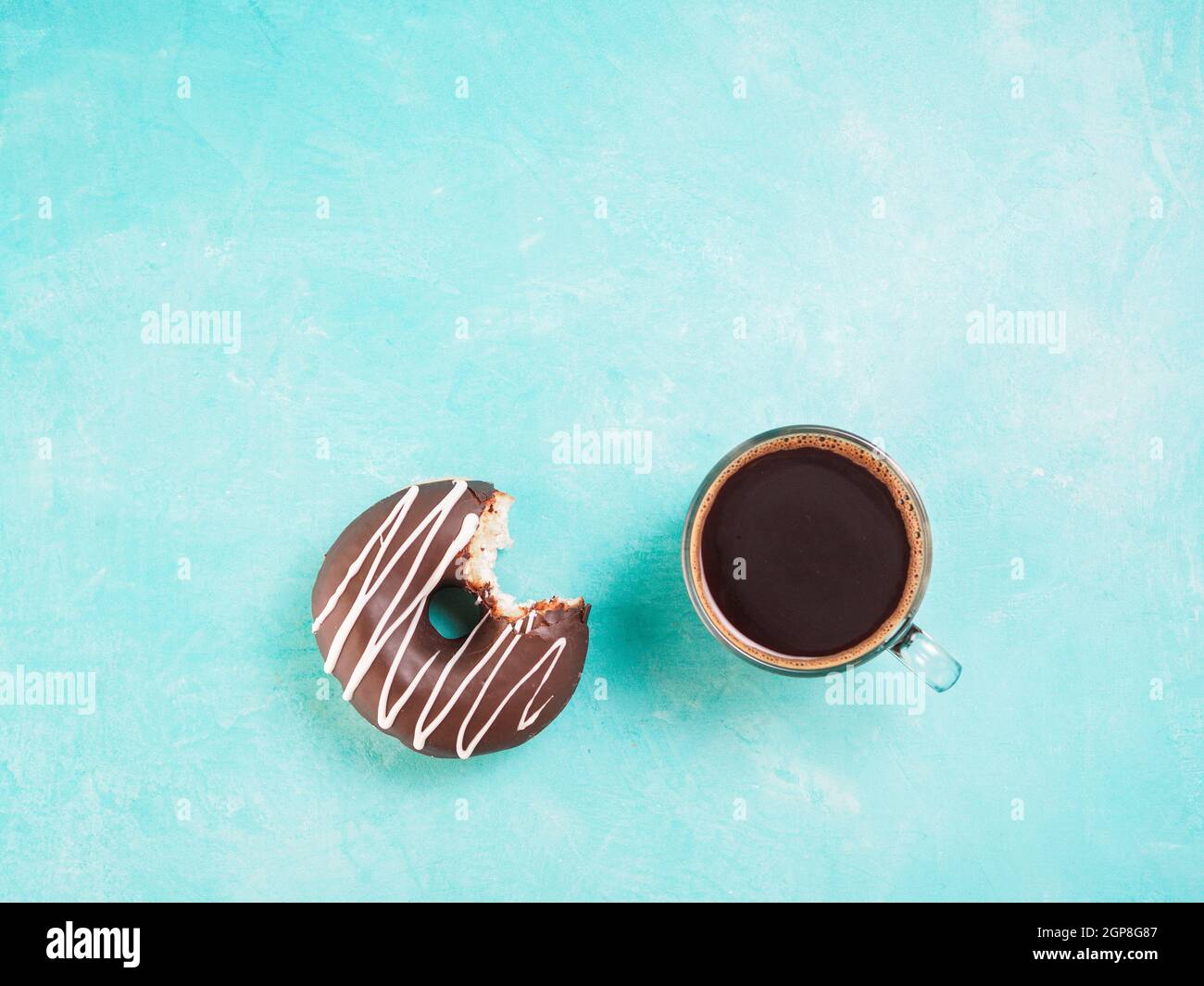 Top view of chocolate donut and coffee on blue concrete background with ...