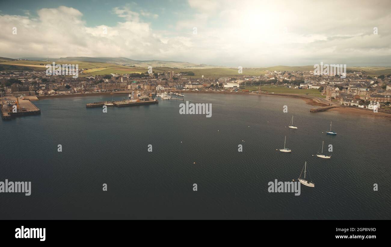 Yachts regatta race at sun ocean coast aerial. Modern buildings at traffic road. Campbeltown pier with water transport at sea bay. Scotland cityscape attraction at summer cruise on sailboats Stock Photo