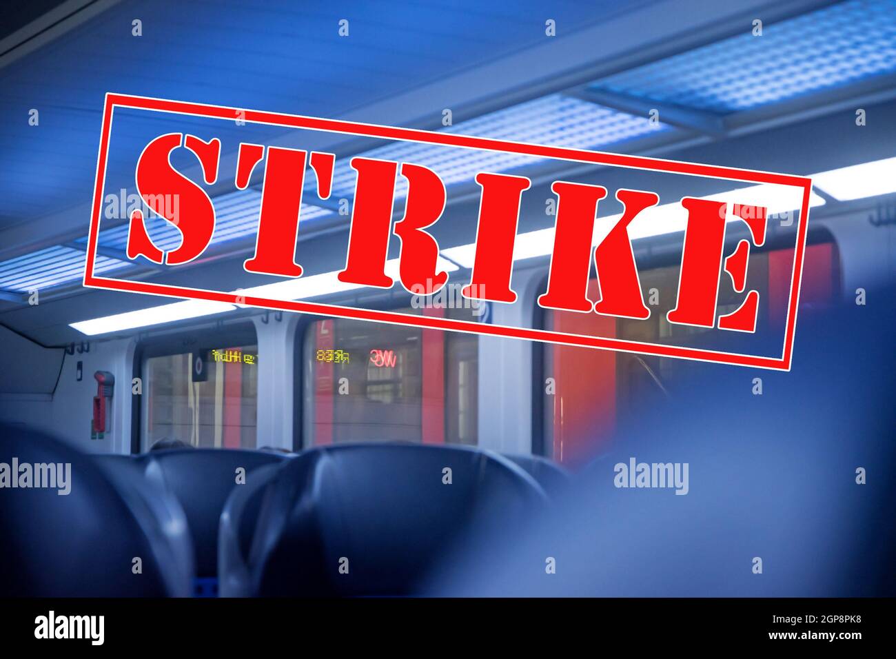 Inside a train without passengers and banner with text Strike, transportation and trade union concept with blurred abstract background in blue and red Stock Photo