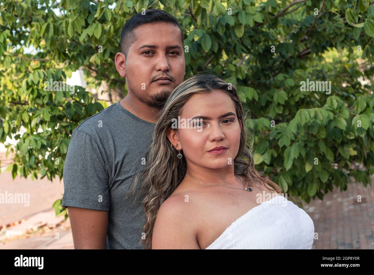 Portrait of a serious Hispanic couple in the park Stock Photo - Alamy