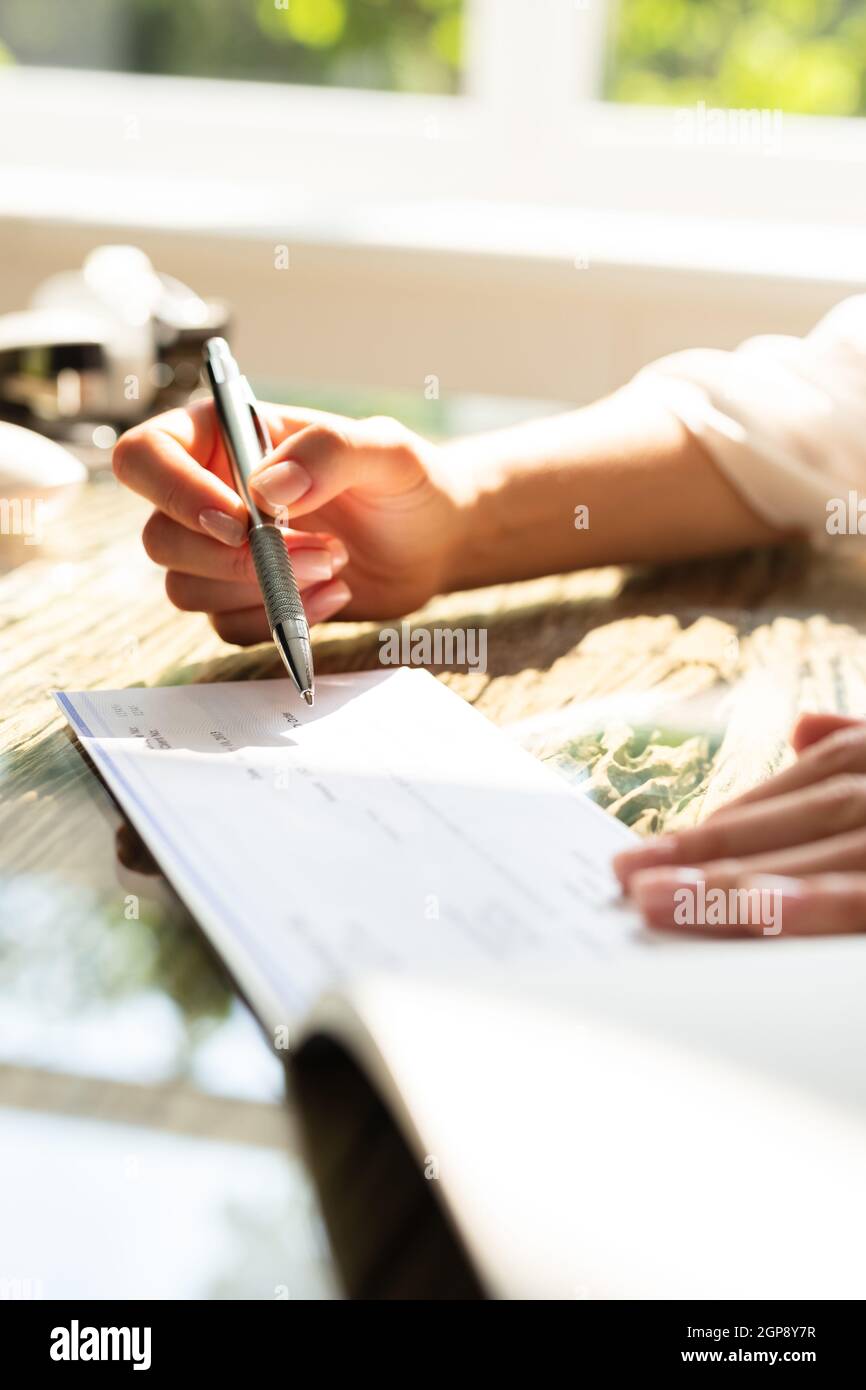 View of Writing Payroll Compensation Check. Bank Pay Cheque Stock Photo - Alamy