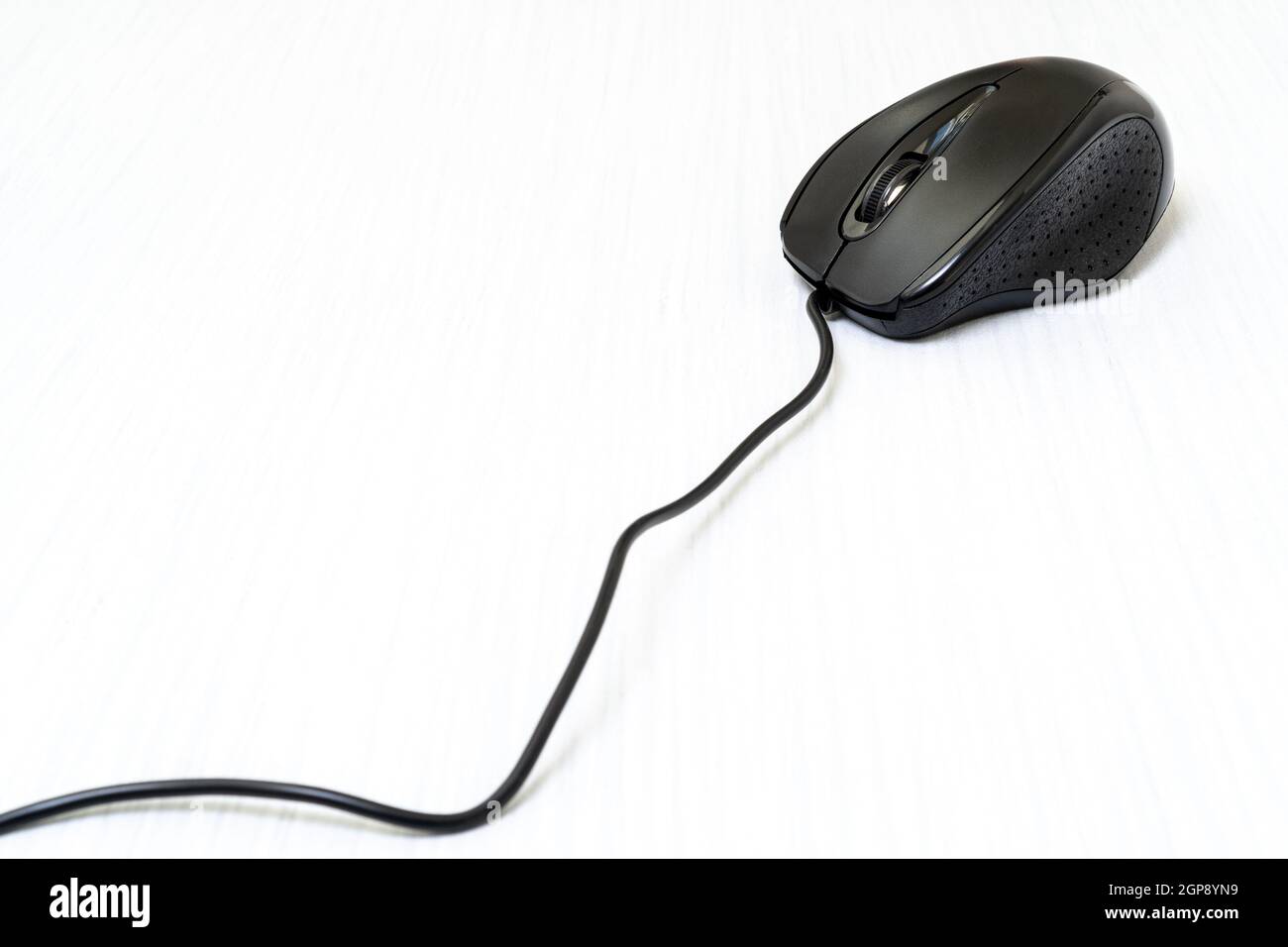 Black computer mouse with cord on white wooden background Stock Photo