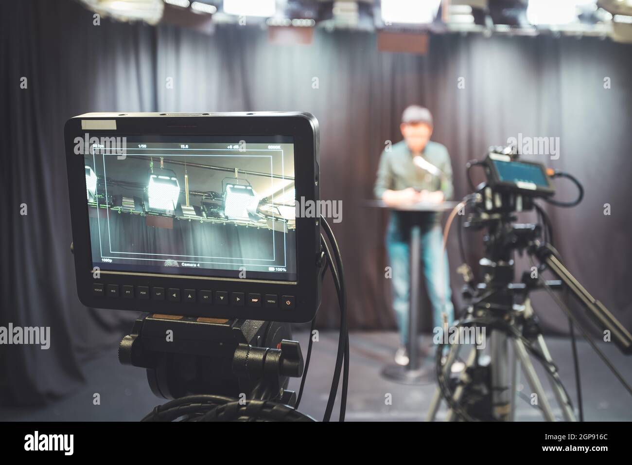 Male journalist in a television studio talks into a microphone, film