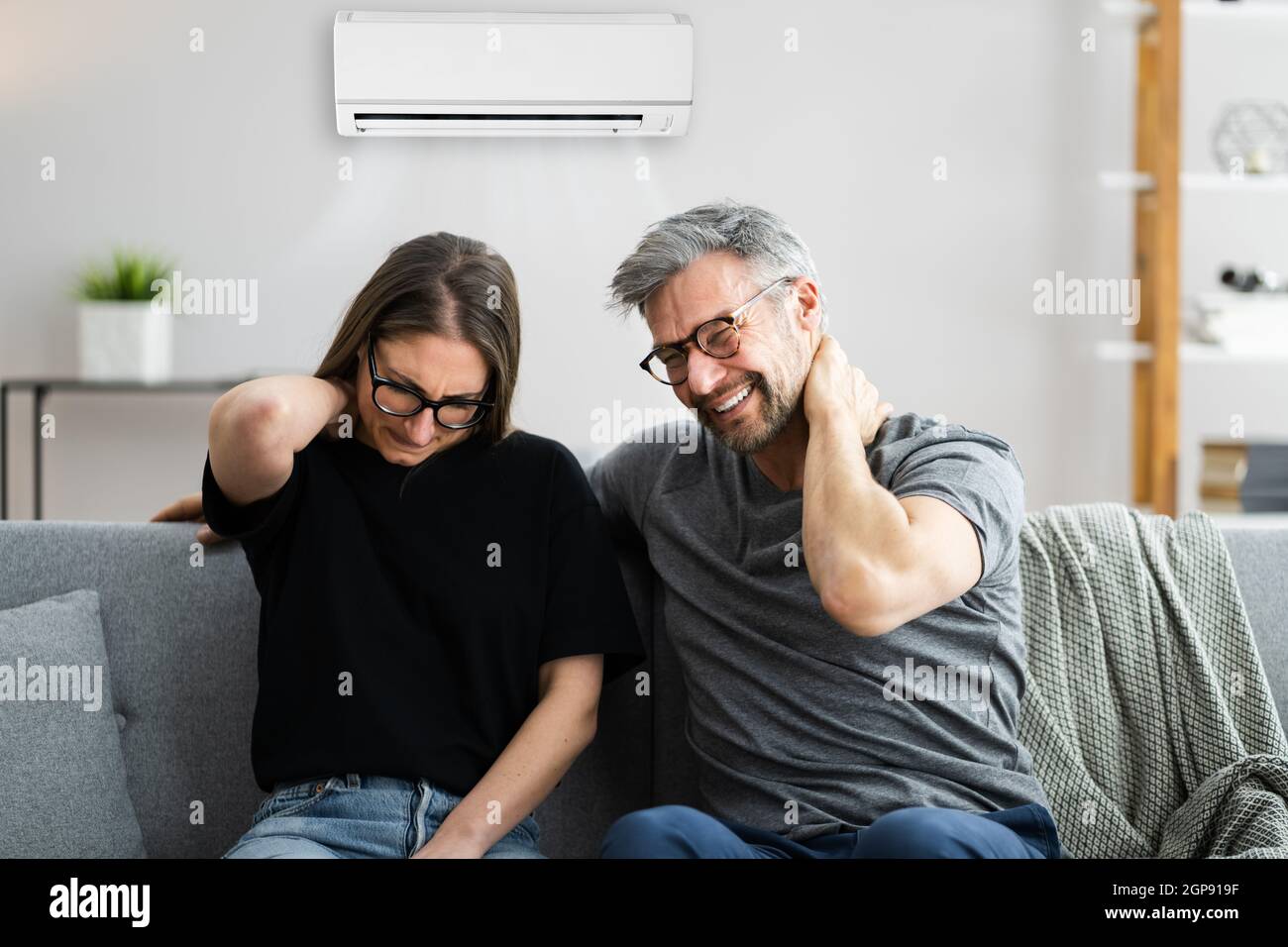Air Conditioner Couple Sneezing And Having Sore Neck Stock Photo