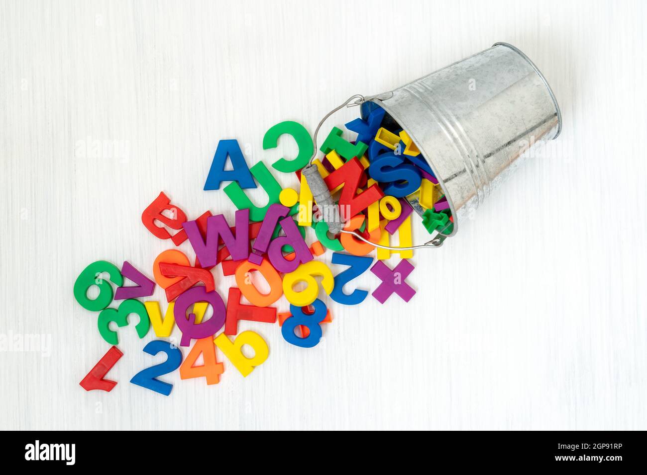 Colorful plastic numbers and letters falling from metal bucket Stock ...
