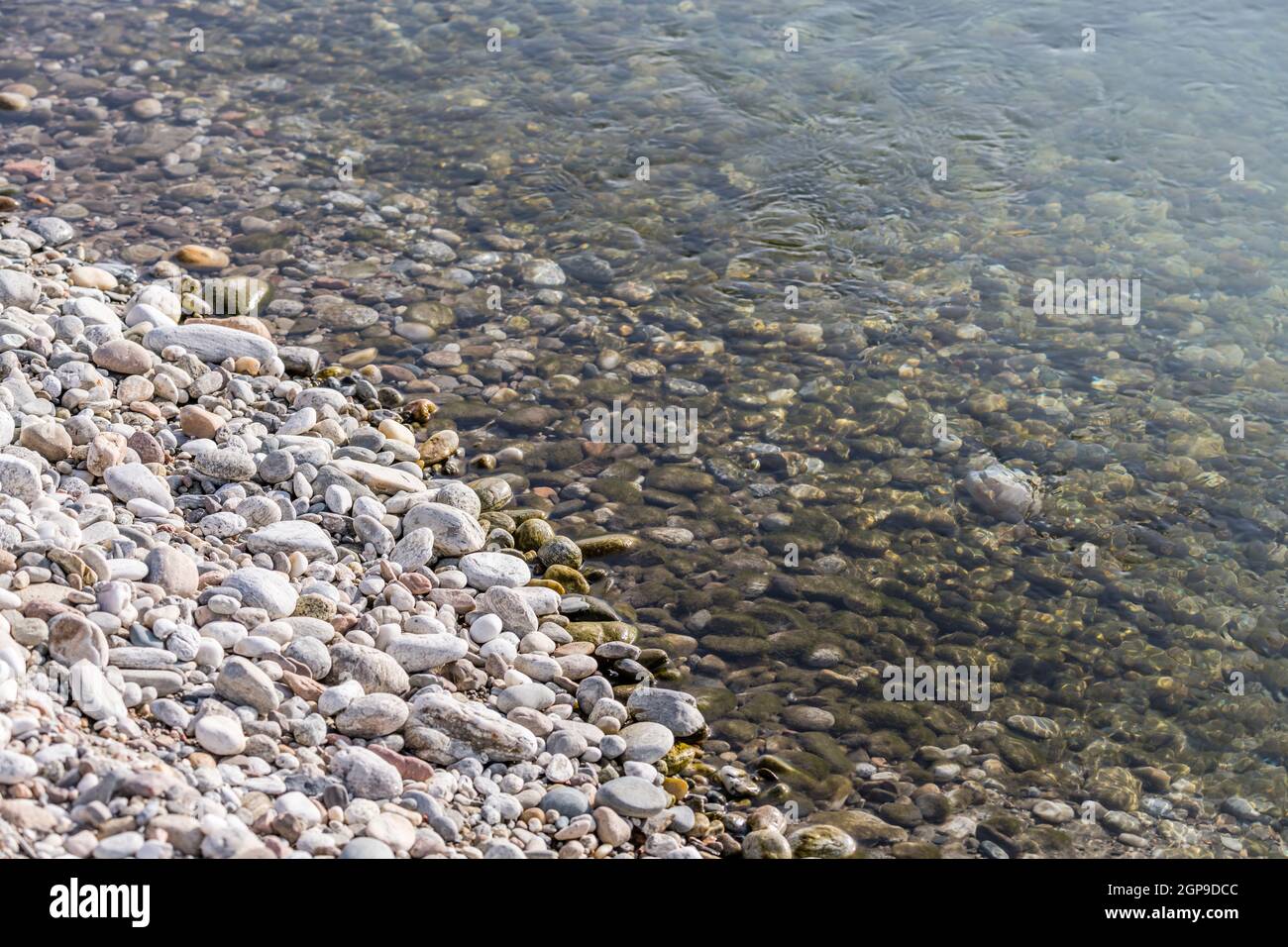 detail of white pebbles and clear waters on shore at Ticino river, shot on bright winter day near Bereguardo, Pavia, Lombardy, Italy Stock Photo