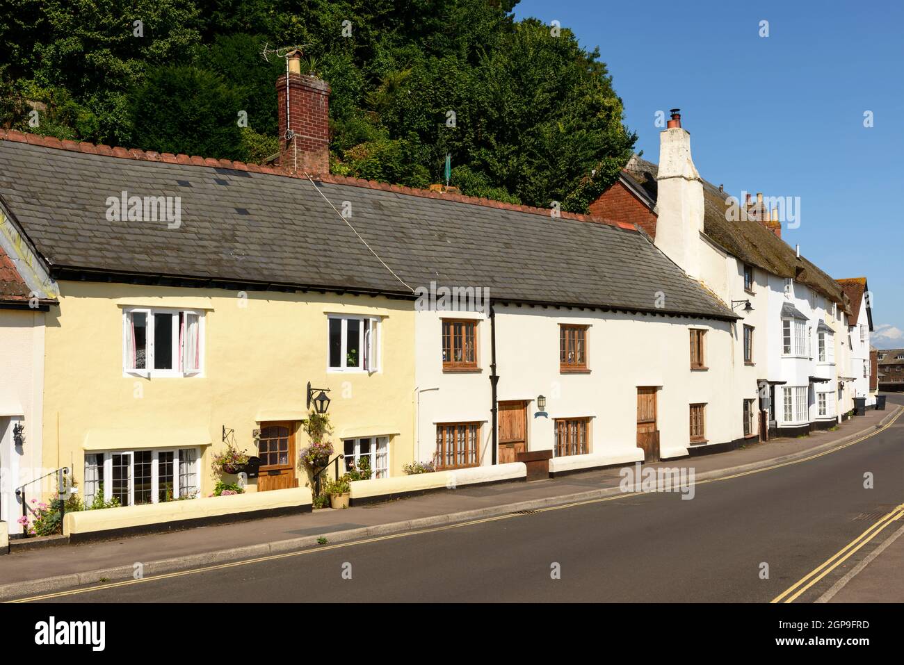 view of medieval cottages built with  stone  prospecting on a street just in front of sea in historic touristic village of  Somerset. Shot in bright l Stock Photo