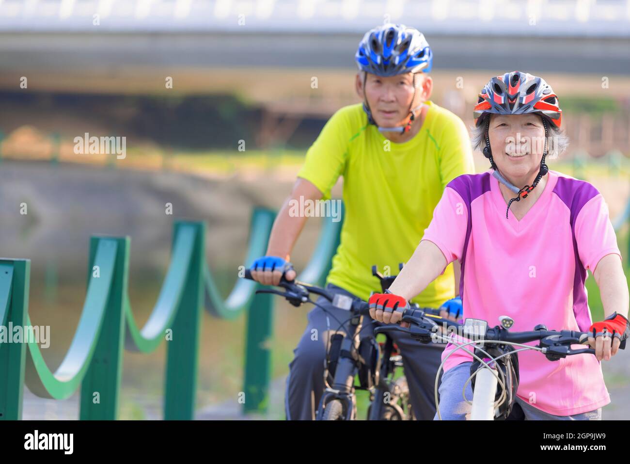 Happy  senior couple exercising with bicycles in the park Stock Photo