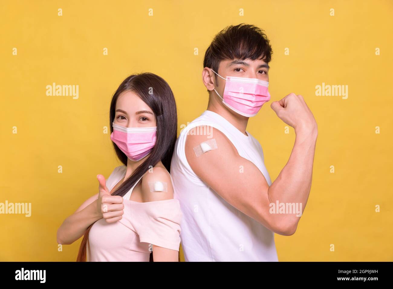 Young couple  receive covid-19 anti virus vaccine and showing thumbs up Stock Photo