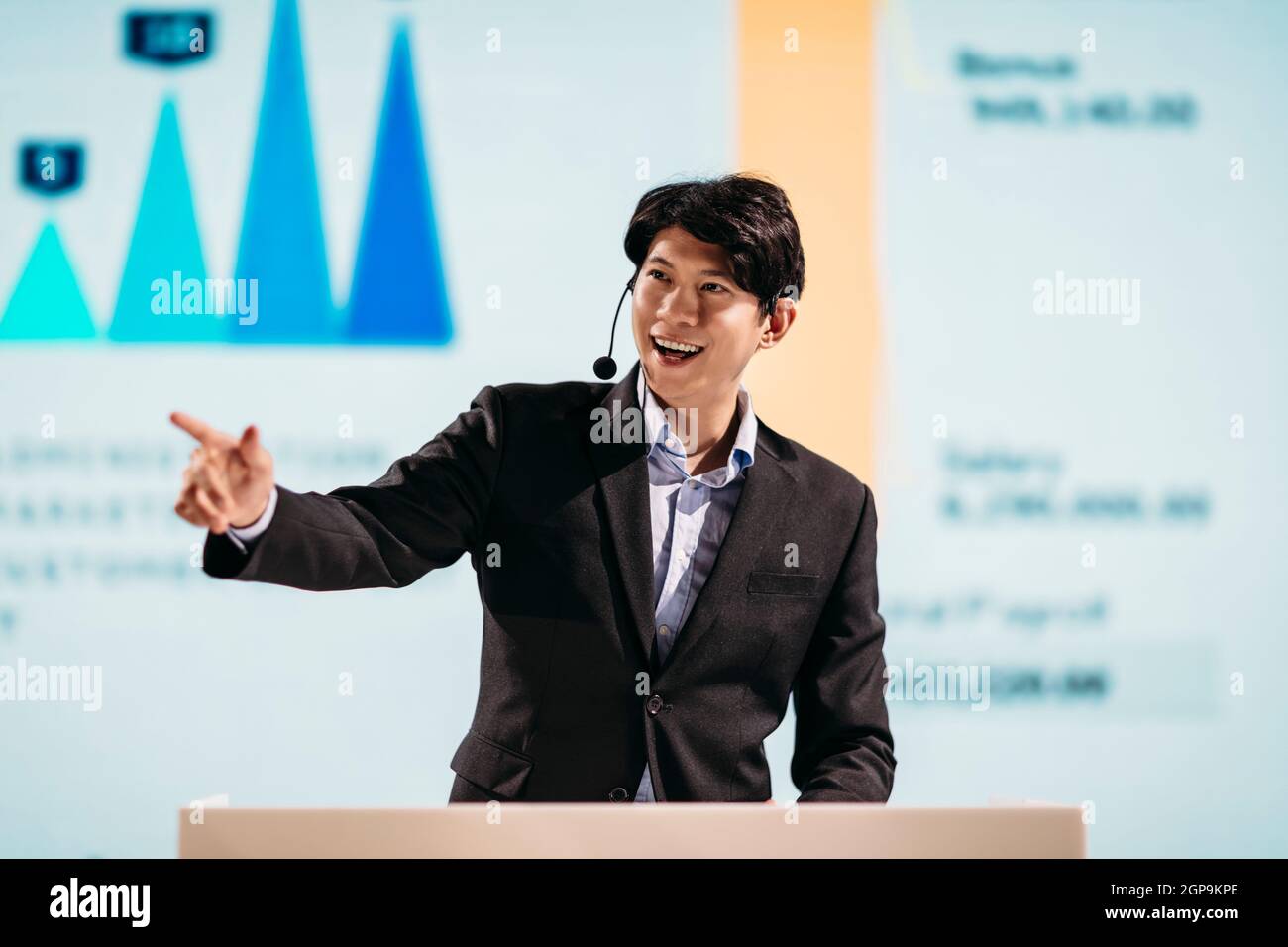 Asian Businessman Stands on Stage for Business Presentation Stock Photo
