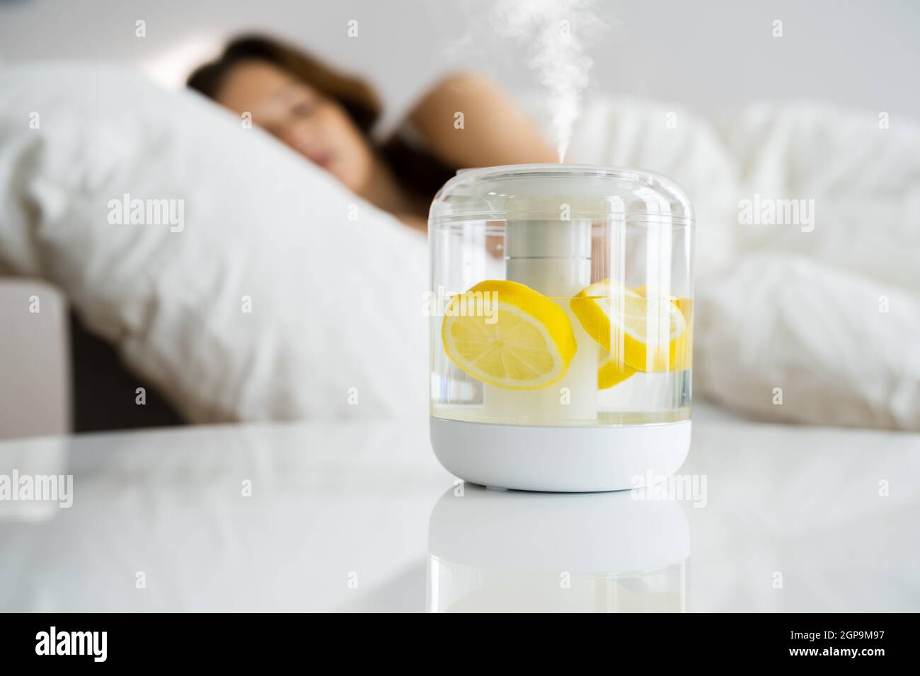 Home Air Humidifier Device In Bedroom Near Woman Sleeping Stock Photo