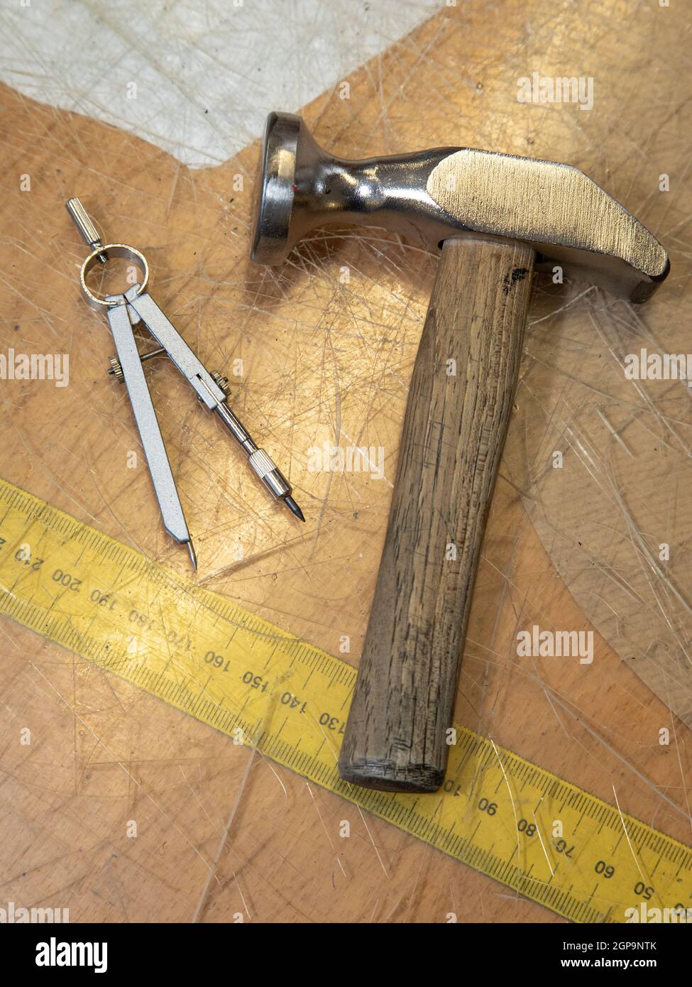 Shoemaker Tools, circle and a measure tape on a desk. Symbolic for craftsman and their workplace. Stock Photo