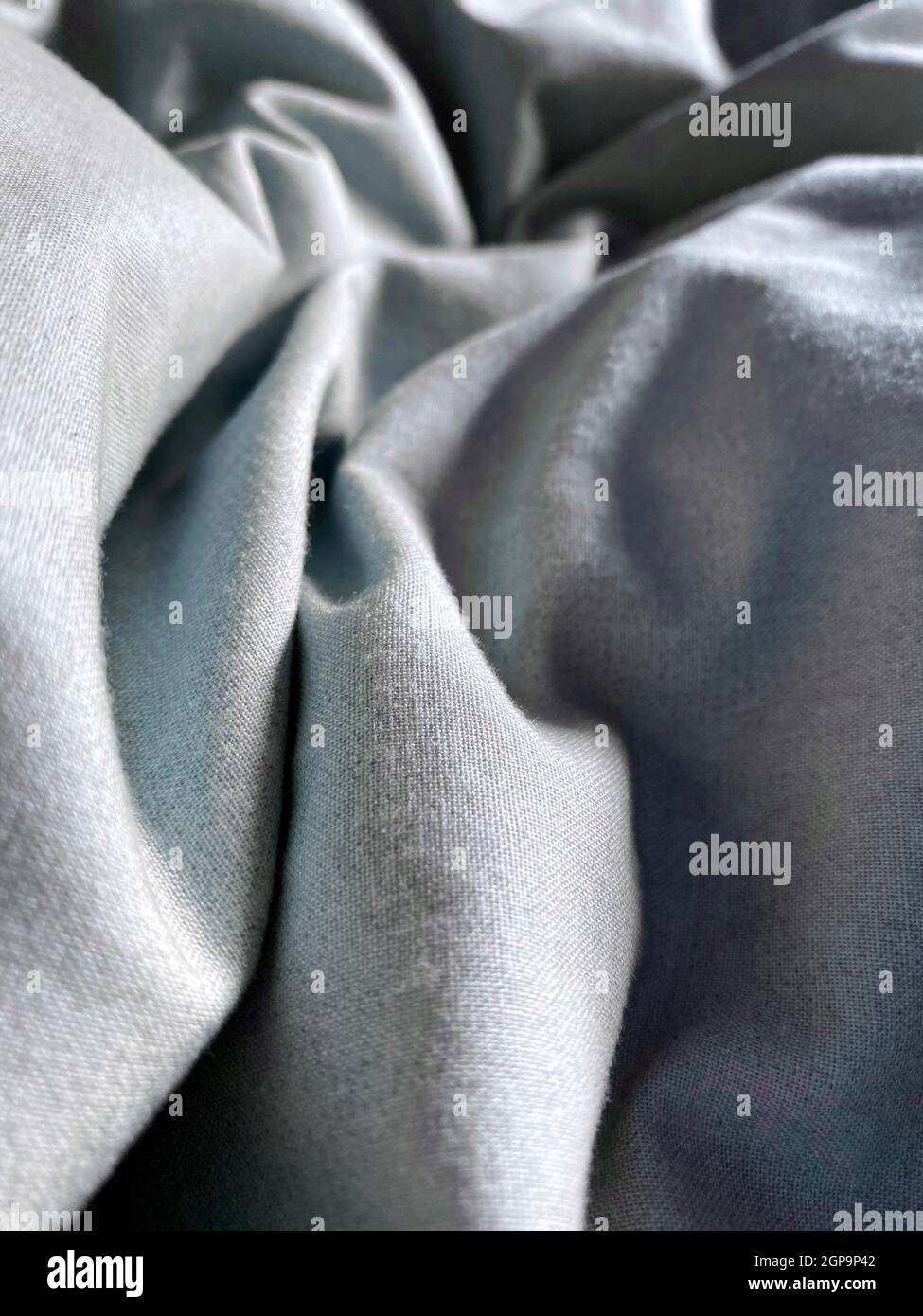 Ruffled bed sheets with sun shining on them Stock Photo