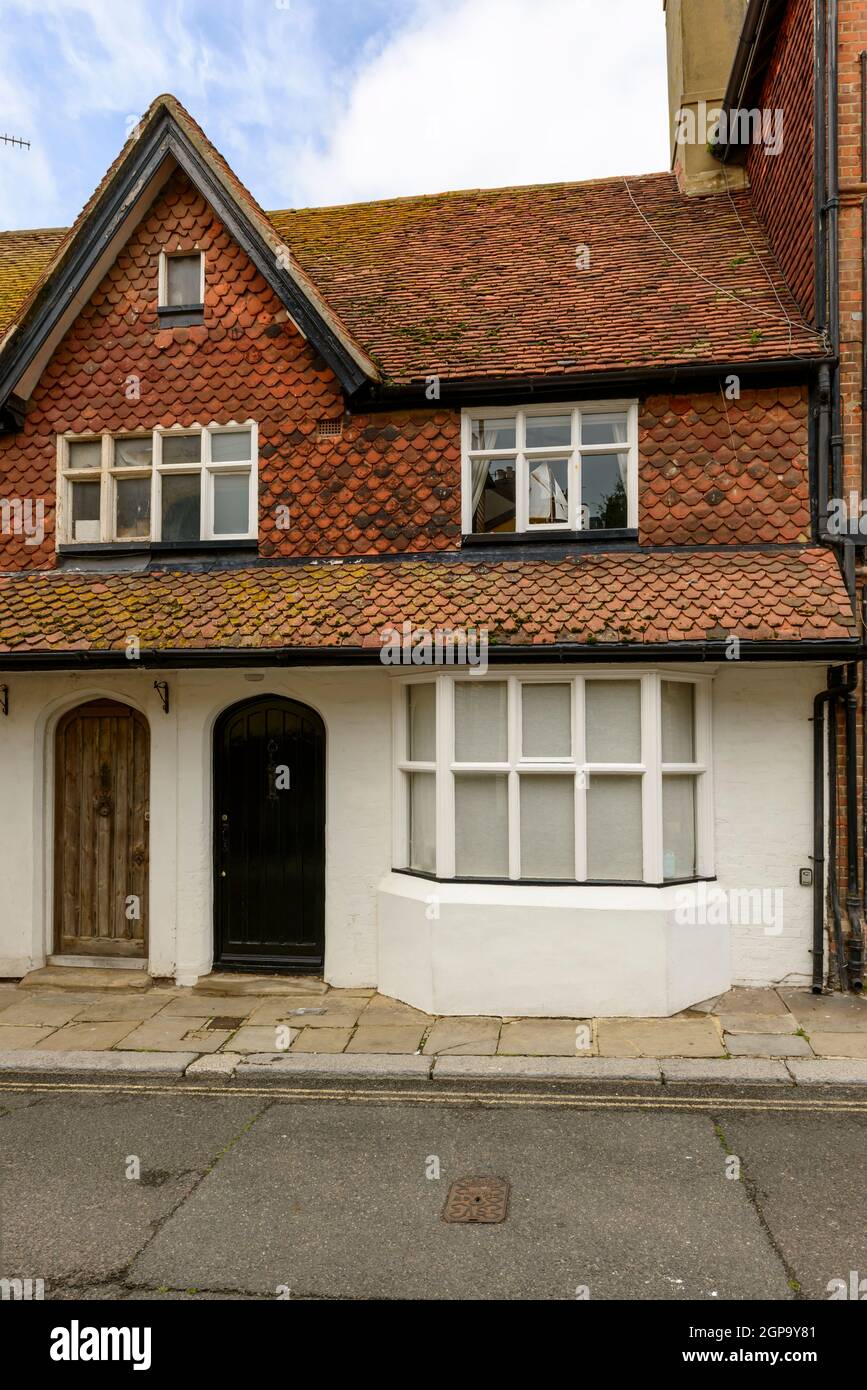 view of old house with traditional shingle roof on a street in the