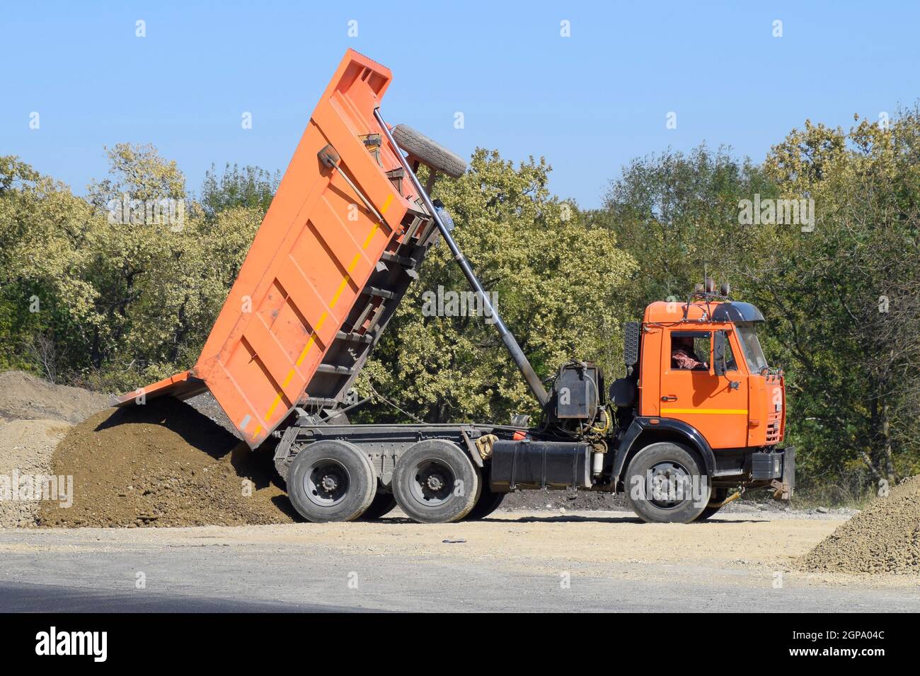 The dump truck unloads rubble. The truck dumped the cargo. Sand and