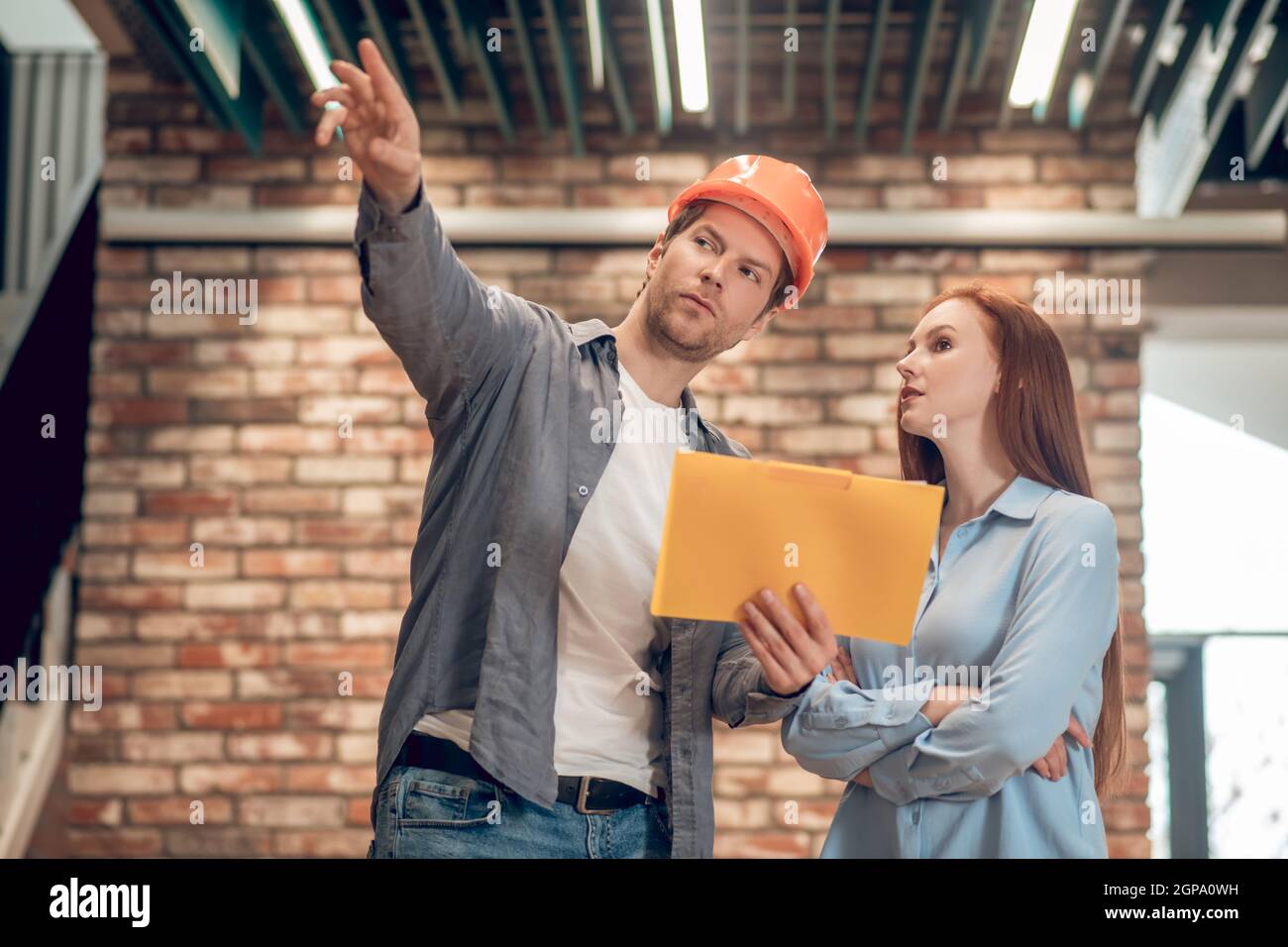 Man explaining showing construction plan to woman Stock Photo