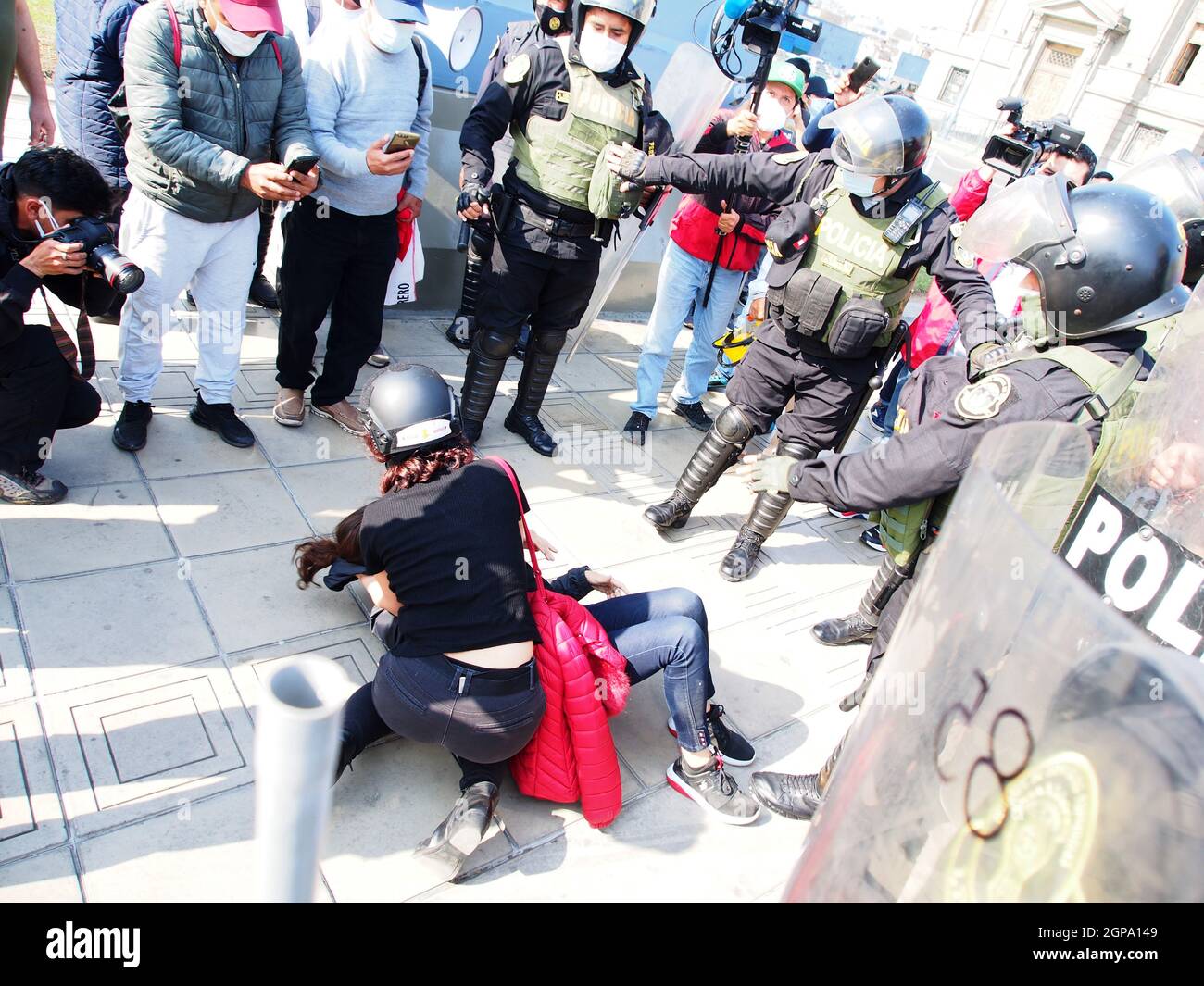 Lima, Peru. 28th Sep, 2021. A woman knocked down on the ground in front of the police when dozens of women, wearing green scarf, carry out a demonstration in front of the Peruvian Judiciary Palace demanding the legalization of abortion. Abortion in Peru, a conservative country, is illegal and punishable Credit: Fotoholica Press Agency/Alamy Live News Stock Photo