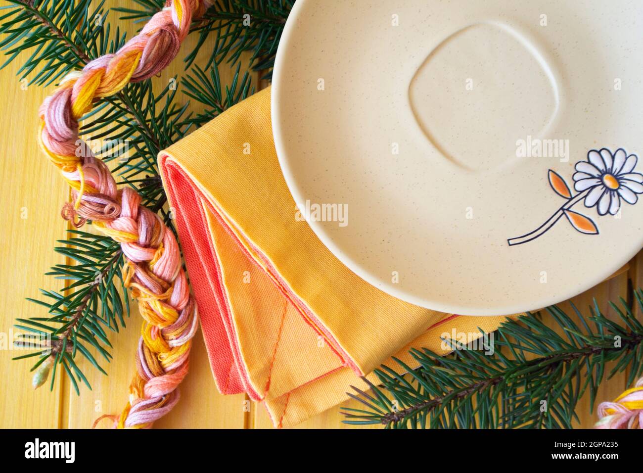 Empty rustic light plate over pastel table. Flat lay, with spruce branch Stock Photo