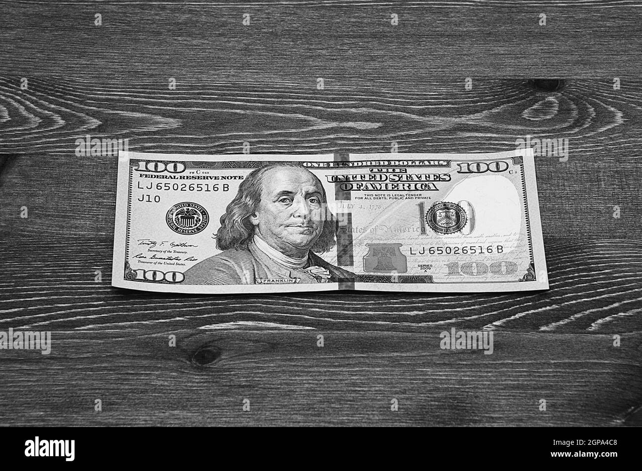 a hundred-dollar bill in cash on a dark wood table. Mockup, layout. Stock Photo