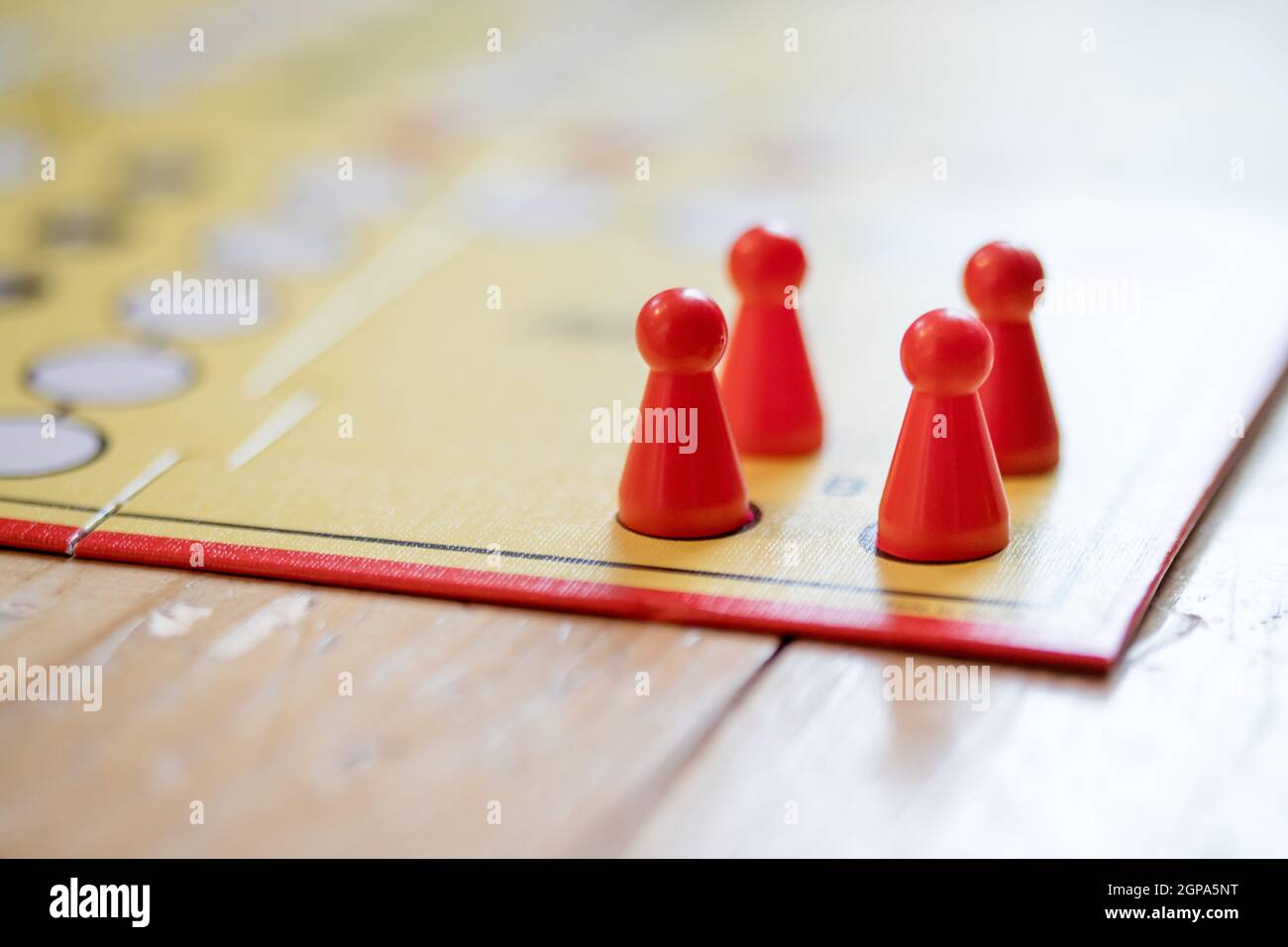 Meeples on a board, ready for playing a parlor game, ludo Stock Photo