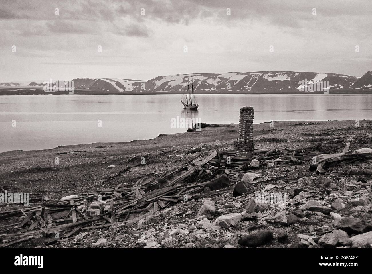 Segelyacht 'Noorderlicht' im Sorgfjord, Spitzbergen. Zu sehen sind die Reste des Überwinterungsquartiers der schwedischen Gradmessungsexpedition von 1 Stock Photo