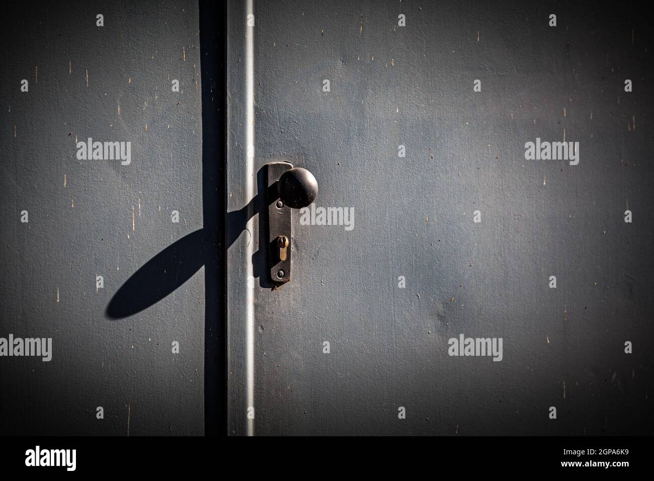 Türgriff einer Stahltür mit Schattenwurf Stock Photo