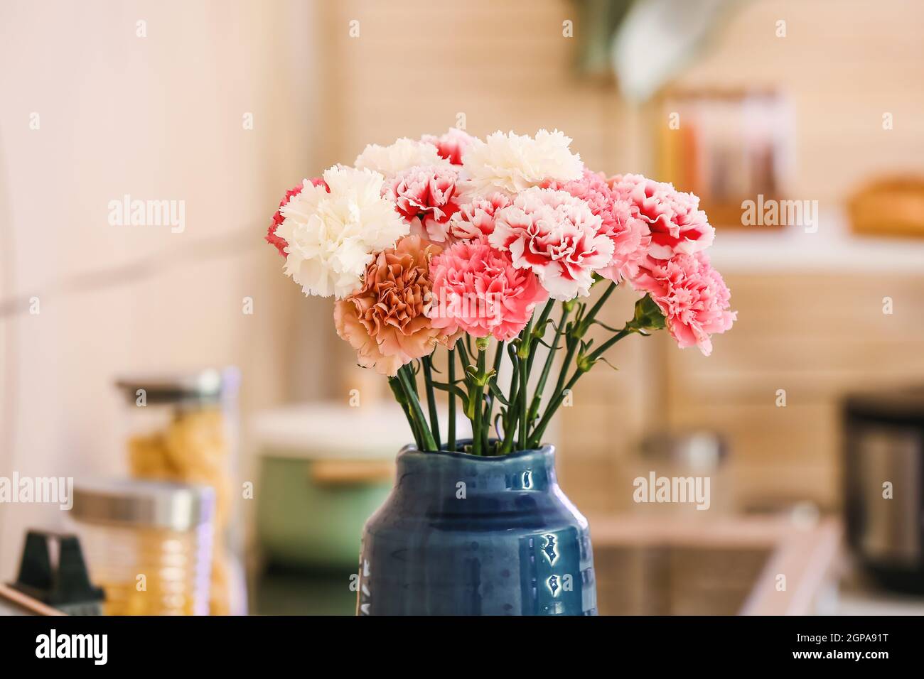 Vase with beautiful carnations in kitchen Stock Photo Alamy