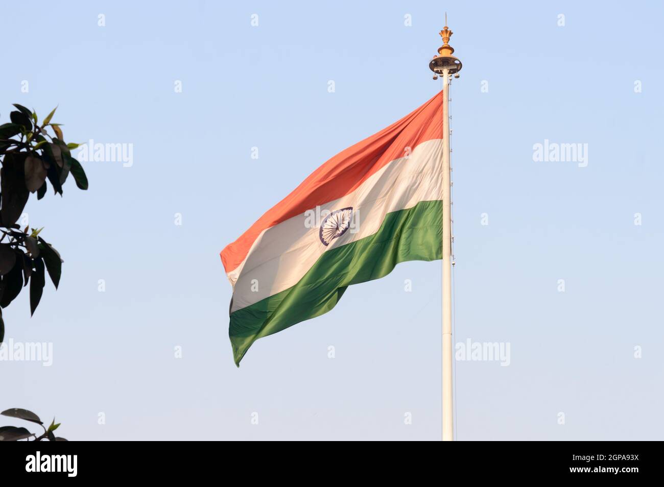 Indian flag flying against blue sky background. The National Flag of India is a horizontal rectangular tricolor (saffron, white and green color) with Stock Photo